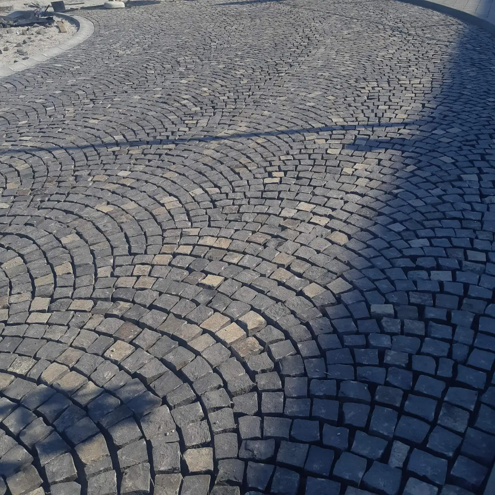Detailný pohľad na precíznu pokládku dlažobných kociek z prírodného kameňa